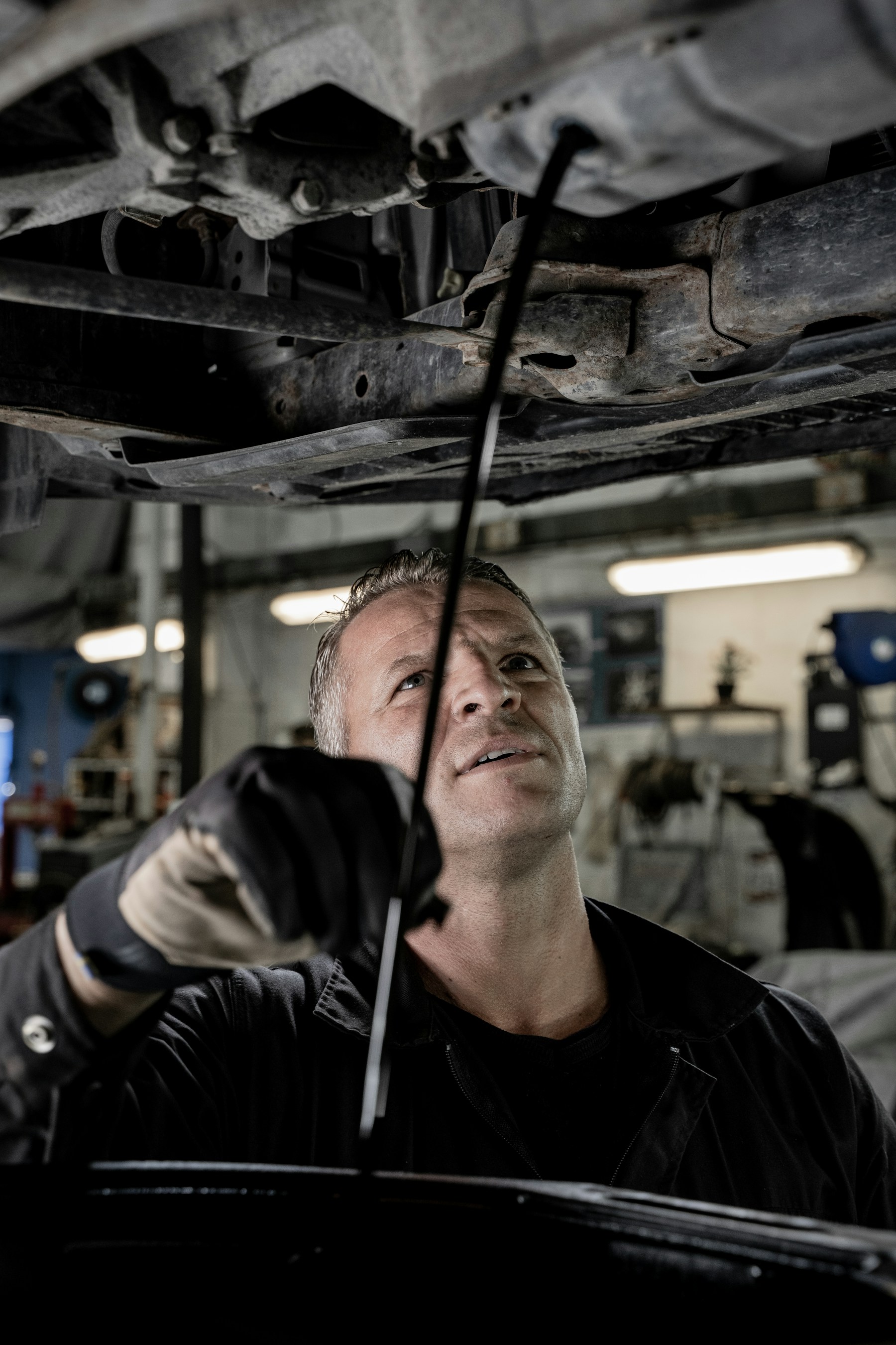Mechanik provádí opravu automobilu v čistém autoservisu