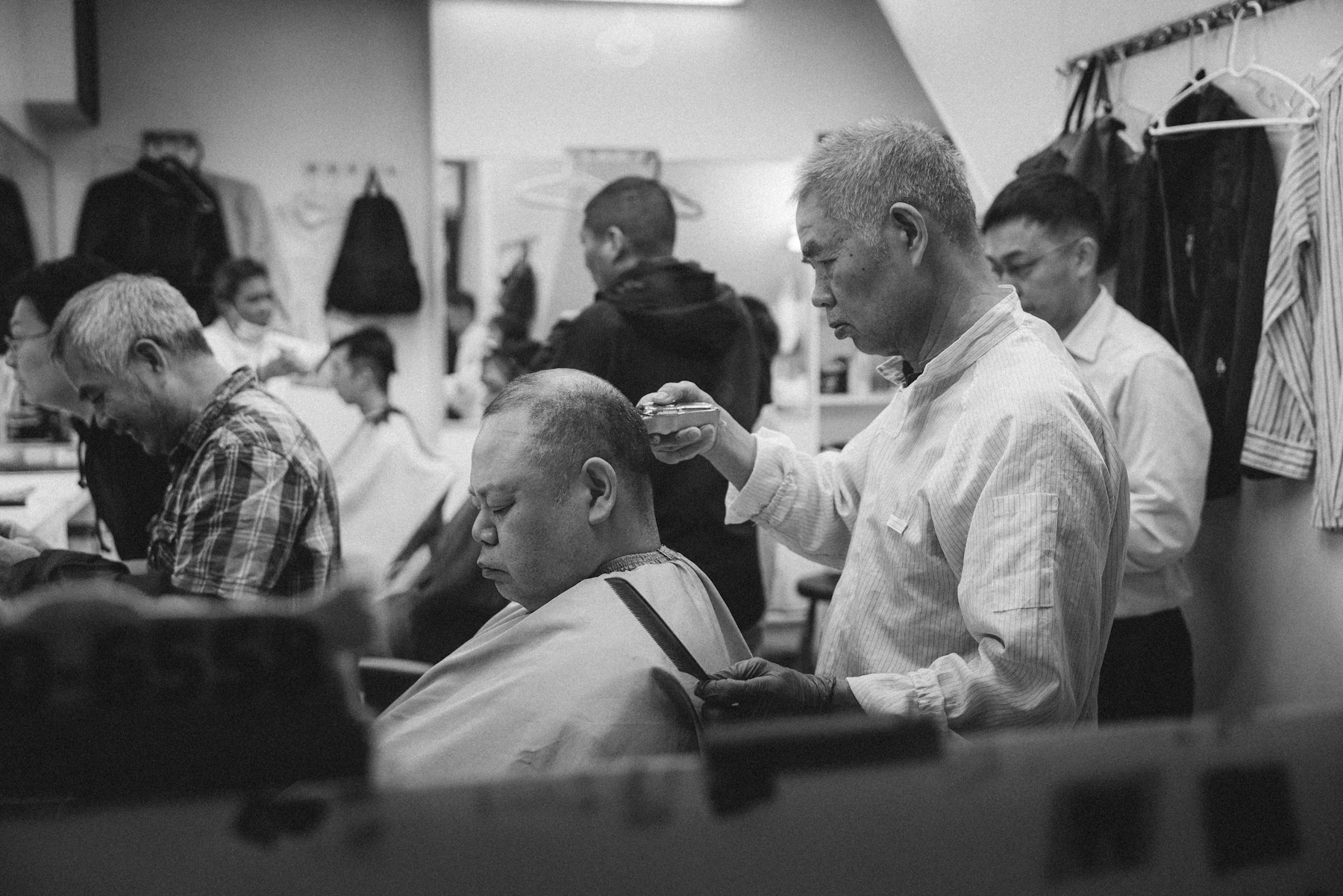 Barber stříhá klienta v moderním městském holičství